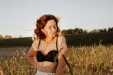 Güneşli bir sonbahar gününde arka planda güzel, genç bir mankenin portresi. Kadınların ve doğanın birliği, barışçıl ruh hali, çevre dostu yaşam.