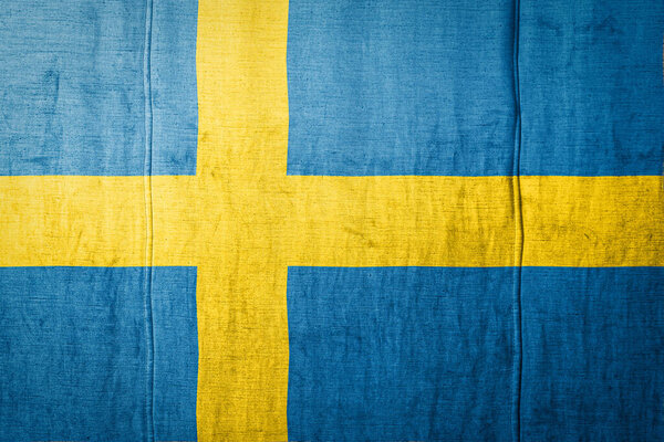 Государственный флаг Швеции, изображающий в красках старый текстиль. Флаг на фоне текстуры ткани
.