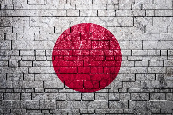 National flag of Japan on brick  wall background.The concept of national pride and symbol of the country. Flag  banner on  stone texture background.