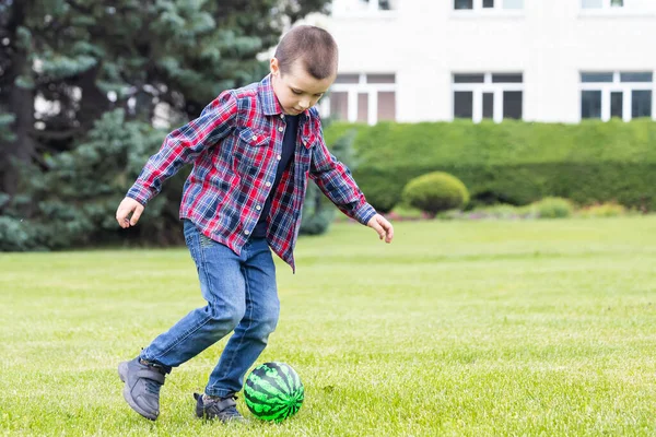 Liten Pojke Spelar Fotboll Med Fotboll Planen Sommarparken Leende Glad — Stockfoto