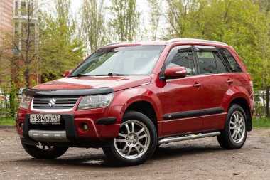 Novosibirsk / Rusya 2 Mayıs 2020: Kırmızı Suzuki Grand Vitara, sıcak bir yaz gününde açık havada park edilmiş pahalı bir geçiş aracı. 