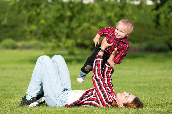 ママは暖かい夏の日に公園で小さな男の子の息子と遊ぶ 抱擁の赤ちゃん 幸せな子供時代のコンセプト 家庭生活の幸福と調和 素晴らしい家族の休暇 — ストック写真