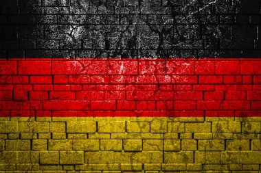 Tuğla duvar arkasında Almanya 'nın ulusal bayrağı. Ulusal gurur kavramı ve ülkenin sembolü. Taş dokusu arka planında bayrak pankartı.