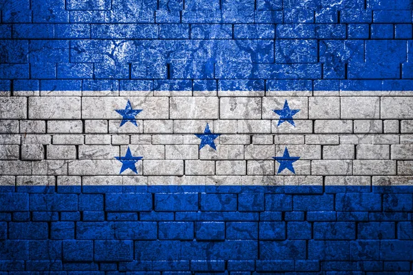 National flag of Honduras on brick  wall background.The concept of national pride and symbol of the country. Flag  banner on  stone texture background.