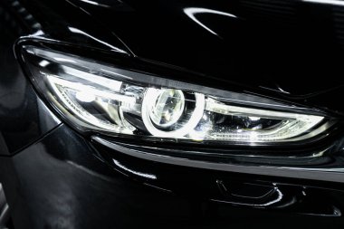 Close up of the car detailing: beauty clean headlights of black SU clipart