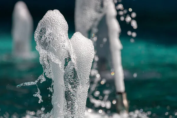 Waterstralen Met Veel Druppels Belletjes Onder Zonnestralen Een Blauwe Achtergrond — Stockfoto