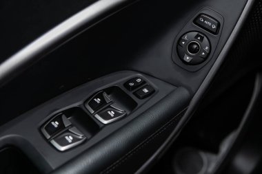 Yeni arabadaki bir kapı kontrol paneline yakın çekim. Pencere kontrol paneli, kapı kilidi düğmesi ve ayna kontrollü kol dinlenmesi.