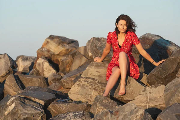 Романтическая Прогулка Кудрявой Женщины Красном Платье Позирующей Камне Море Концепция — стоковое фото