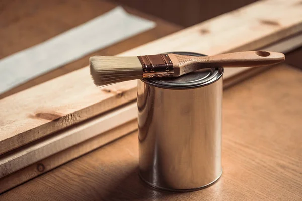 金属罐的特写 带有油漆 木材用清漆 是车间木制桌子上的新刷子 — 图库照片