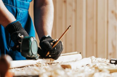Marangozu tahta tahtada kalem ve mezura iziyle kapatın. İnşaat endüstrisi, ev işi, kendin yap. Tahtayla çalış.