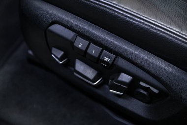 Siyah koltuk kaplaması, araç panelinde düğmeler, ticari işaret yok.