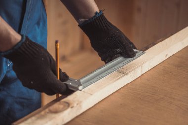 Kalemle çizgi çizen ve cetvel olarak çiğ tutan bir adam. Ev dekorasyonu, DIY ve ev dekorasyonu 
