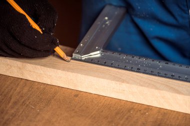 Kalemle çizgi çizen ve cetvel olarak çiğ tutan bir adam. Ev dekorasyonu, DIY ve ev dekorasyonu 