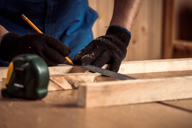 Kalemle çizgi çizen ve cetvel olarak çiğ tutan bir adam. Ev dekorasyonu, DIY ve ev dekorasyonu 