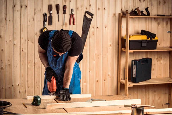 A carpenter using a jigsaw to cut wood cuts bars