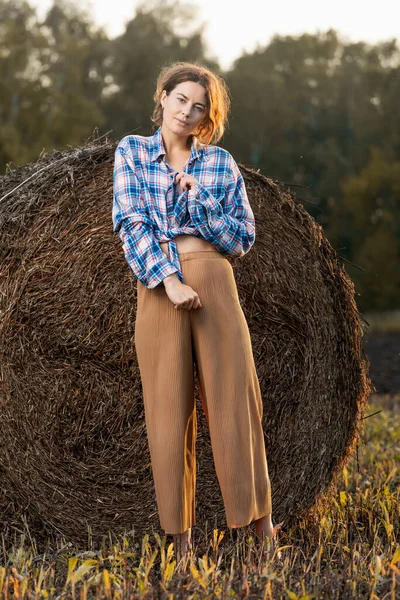 Κομψό Κορίτσι Στέκεται Στο Παρασκήνιο Των Haystacks Ένα Καλοκαιρινό Πεδίο — Φωτογραφία Αρχείου