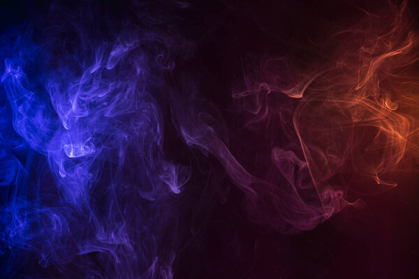 Frozen abstract movement of explosion smoke multiple colors on black background. Background from the smoke of vap