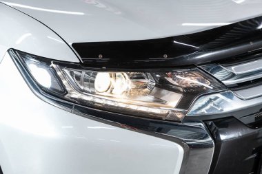 Novosibirsk, Rusya 07 Ağustos 2020: Mitsubishi Outlander, Ayrıntılı aracın güzelliği: beyaz SUV 'nin temiz farları