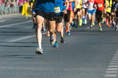 Novosibirsk, Rusya - 12 Eylül 2020: Raevich Half Marathon. Asfalttaki koşu pisti ve saha atletlerinin bacaklarına yakın çekim. Maraton koşucuları özel spor ayakkabılarla