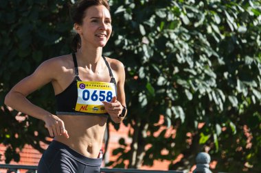 Novosibirsk, Rusya - 12 Eylül 2020: Raevich Half Marathon. Şehir yarışmasında koşan güzel bir genç kadın.