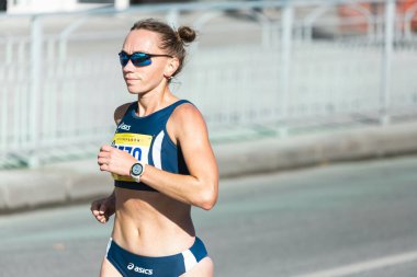 Novosibirsk, Rusya - 12 Eylül 2020: Raevich Half Marathon. Şehir yarışmasında koşan güzel bir genç kadın.