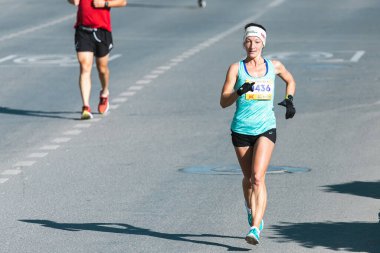 Novosibirsk, Rusya - 12 Eylül 2020: Raevich Half Marathon. Şehir yarışmasında koşan güzel bir genç kadın.