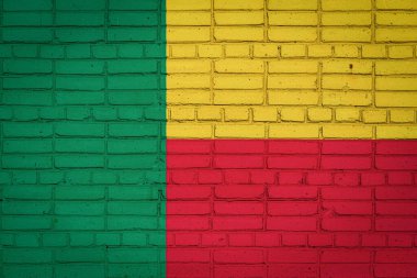 Benin 'in ulusal bayrağı eski bir tuğla duvarda boya renkleriyle tasvir ediliyor. Tuğla duvar arka planında bayrak pankartı.