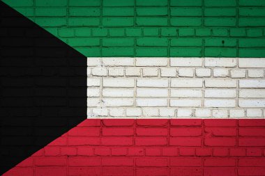 Kuveyt 'in ulusal bayrağı eski bir tuğla duvarda boya renkleriyle tasvir ediliyor. Tuğla duvar arka planında bayrak pankartı.