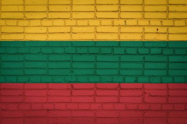 Litvanya 'nın ulusal bayrağı eski bir tuğla duvarda boya renkleriyle tasvir ediliyor. Tuğla duvar arka planında bayrak pankartı.