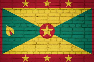 Grenada 'nın ulusal bayrağı eski bir tuğla duvarda boya renkleriyle tasvir ediliyor. Tuğla duvar arka planında bayrak pankartı.