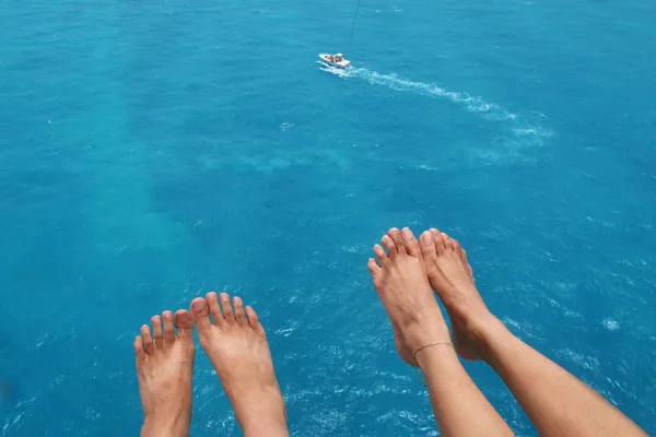 Deniz arka planda sürat teknesi ile çift parasailing, ayak görünümü                               