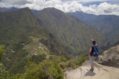 Machu Picchu, Peru Tarihi Mabeyi ve Unesco Dünya Mirası Alanı. Dünyanın Yeni Yedi Harikasından biri. Bulutlu bir gün, az bulutlu, öğleden sonra. Kadın. Machu Picchu, Peru.