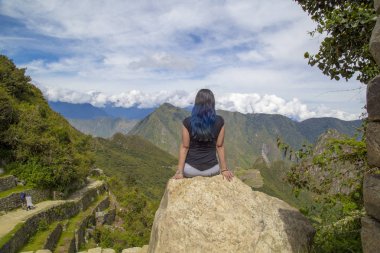 Machu Picchu, Peru Tarihi Mabeyi ve Unesco Dünya Mirası Alanı. Dünyanın Yeni Yedi Harikasından biri. Bulutlu bir gün, az bulutlu, öğleden sonra. Kadın. Machu Picchu, Peru.