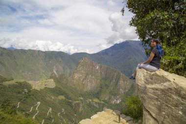 Machu Picchu, Peru Tarihi Mabeyi ve Unesco Dünya Mirası Alanı. Dünyanın Yeni Yedi Harikasından biri. Bulutlu bir gün, az bulutlu, öğleden sonra. Kadın. Machu Picchu, Peru.