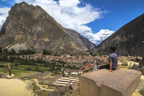 Turista observando la ciudad con una vista panorámica en Ollantaytambo es una ciudad en el Valle Sagrado del Perú, que se encuentra al sur sobre el río Urubamba y está rodeado de montañas nevadas . — Foto de Stock