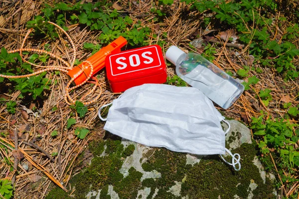 antibacterial gel, medical mask and s.o.s aid tools in the forest