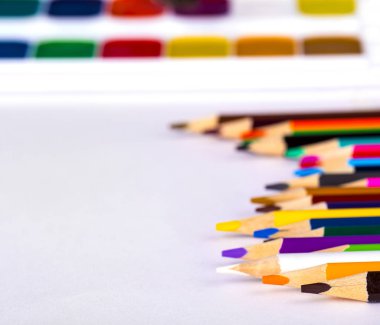 renkli kalemler ve beyaz zemin üzerine suluboya