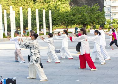 Sanya, Çin: 11 Kasım 2017: kadınlar ve erkekler sokakta Park jimnastik Wushu.
