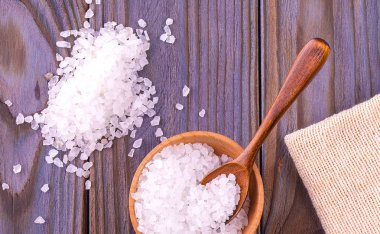 Deniz tuzu fincanda, kaşık ve çuval bezi ahşap masada 