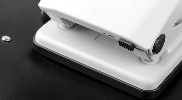 Hole punch (office accessory) on the dark paper