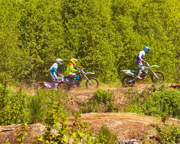 Les motocross pratiquent des tours sur leurs motos sur un vélo ensoleillé — Photo