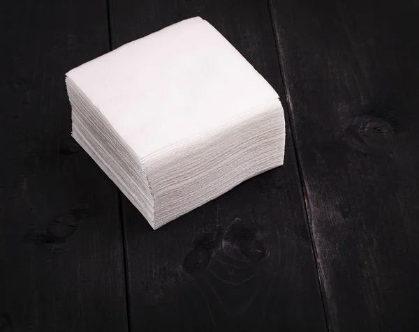 Το λευκό χαρτί πετσέτα σε παλιό μαύρο ξύλινο τραπέζι — Φωτογραφία Αρχείου
