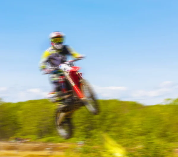 Размытое изображение мотоциклиста во время мотокросс-гонки — стоковое фото
