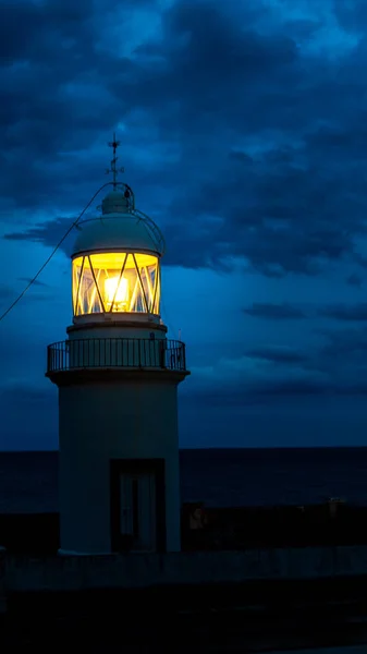 The Lighthouse glowing at dark night on coast Spain — Stock Photo, Image