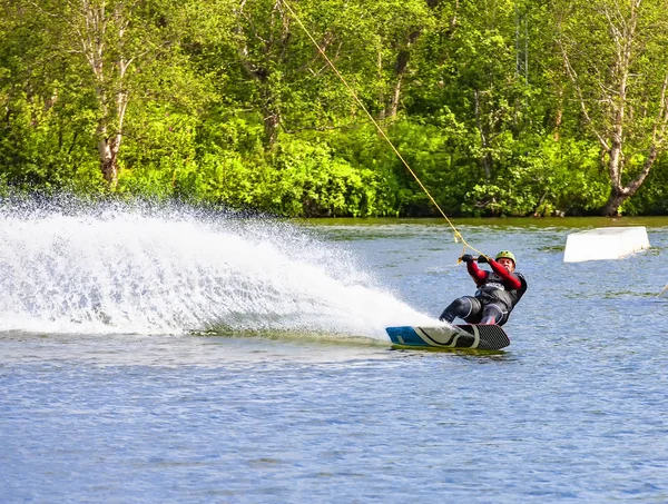 Man wakeboarding on lake in Kamchatka behind boat — Stock Photo, Image