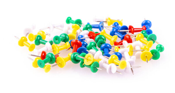 Colored pushpins on white background