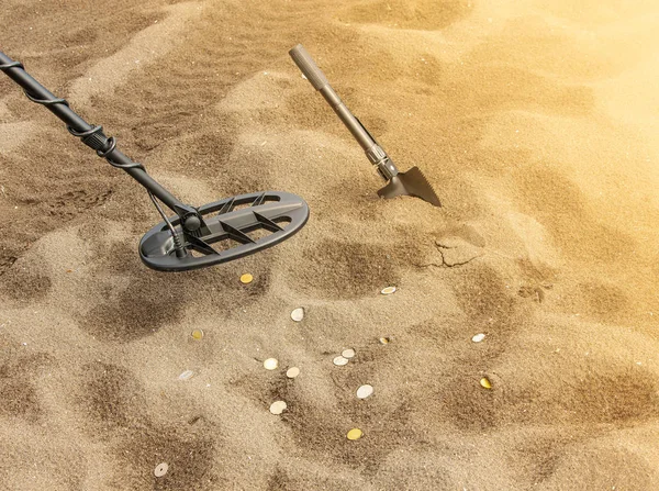 O detector de metais, anel e pá na areia — Fotografia de Stock