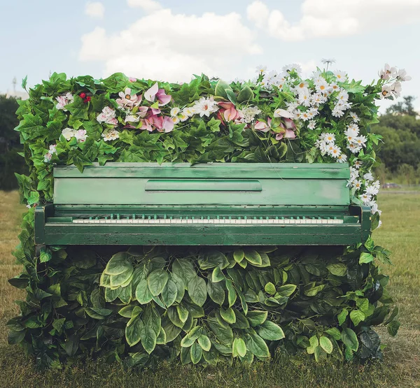 Viejo piano en hermosas flores —  Fotos de Stock