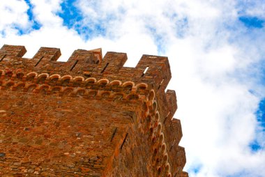 Mavi gökyüzünün arka planındaki bulutlu eski kale.