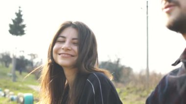 Romantik bir çift oturuyor ve erkek kız arkadaşı için gitar çalıyor. Açık hava..